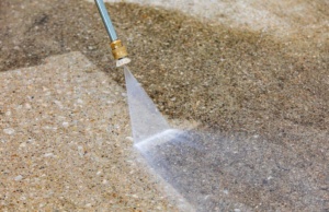 Cleaning driveway using power washer.